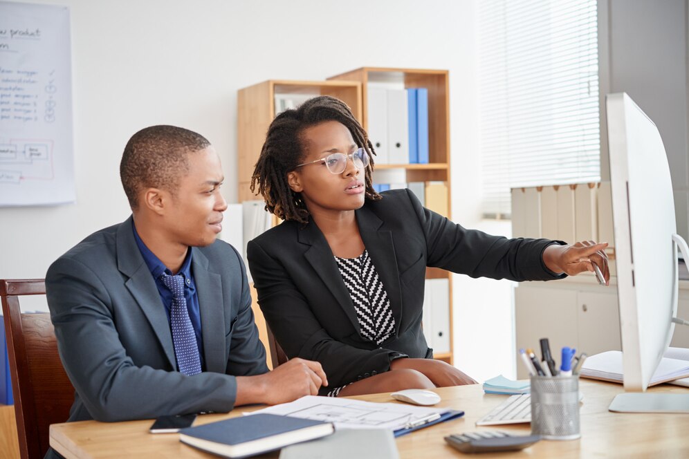 black-male-female-colleagues-sitting-office-looking-computer-screen-together_1098-20605